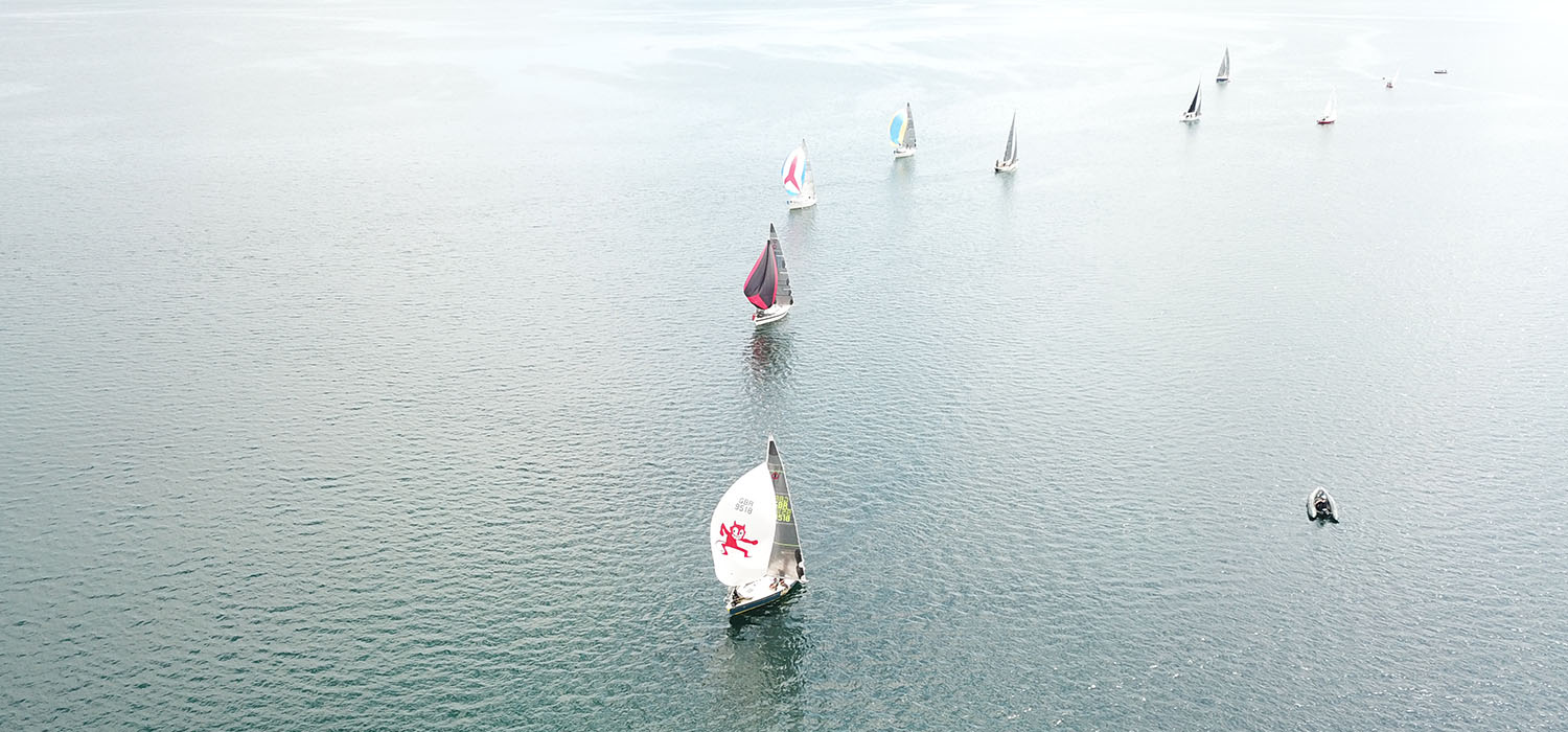 Impala fleet racing from above, with an Impala using Dart Sails winning and flying a spinnaker
