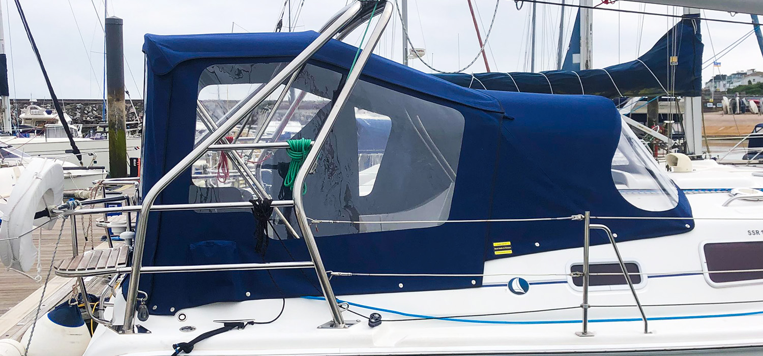 Sprayhood and enclosure Dark blue Sprayhoods and enclosure, designed, patterned and made by Dart Sails and Covers for the Legend 33, fitted on the boat in the marina