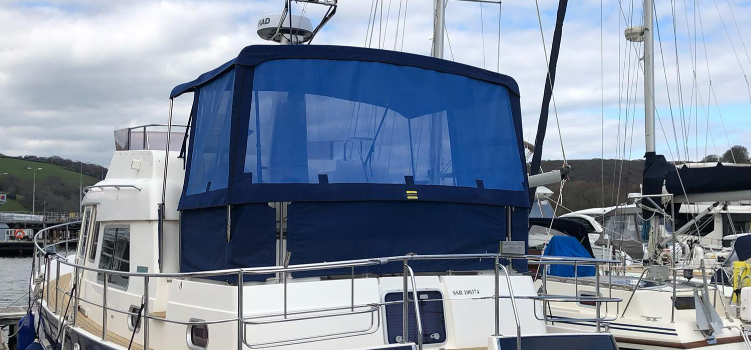 New Cover and Enclosure Bespoke new enclosure with windows, patterned and made by Dart Sails and Covers, for a motor boat on the marina